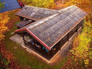 Eine Holzhütte mit geneigtem Dach und einer kleinen Veranda.