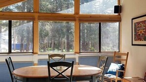 A room with a large window, a round table, and four chairs. - Bright and Airy Condo, Sleeps 4! - Creekside #103 by Bear Valley Vacation Rentals (Arnold)