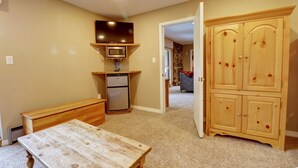 A compact kitchen with a wooden table, a microwave, and a refrigerator. - Ski-In Ski-Out Center Village Hotel Room - CM217 by Redawning (Copper Mountain)