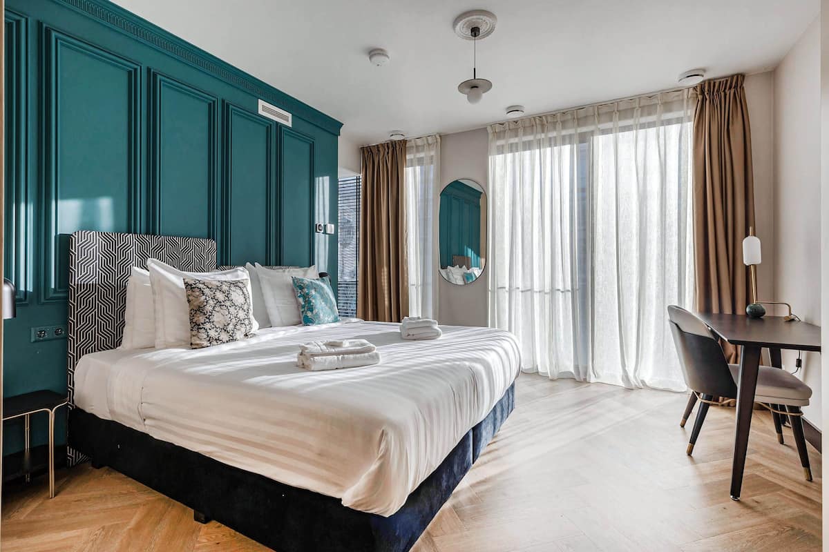 Una camera d'albergo con un letto grande, una scrivania e una sedia.