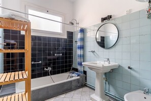 Bathtub, hair dryer, towels, shampoo