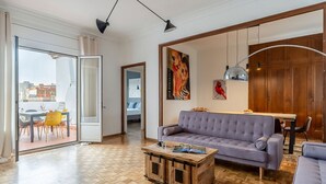 Un salon moderne avec un canapé, une table basse et un coin repas.