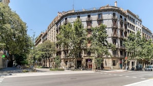 A multi-story building with a curved facade, balconies, and a street view. - Sagrada Familia view in BCN center (Barcelona)