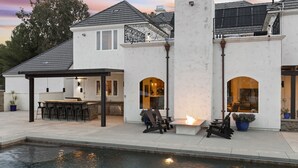 A modern house with a pool, outdoor seating, and a patio area. - Chateau Vino - French Style Chalet (Temecula)