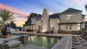 A two-story house with a swimming pool, outdoor seating, and a patio area. - Chateau Vino - French Style Chalet (Temecula)
