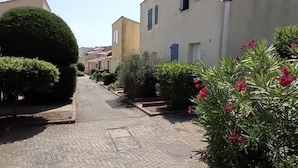 Una calle pavimentada con edificios a ambos lados, algunos con antenas parabólicas.