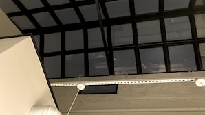 Un plafond doté d’une grille de fenêtres et d’un panneau de plafond blanc.