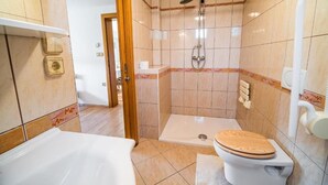 Un baño con ducha, inodoro y lavabo.