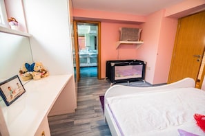 A bedroom with a bed, a desk with a teddy bear, a television, and a bathroom visible through an open door. - Farm Stay Ana (Ivancna Gorica)