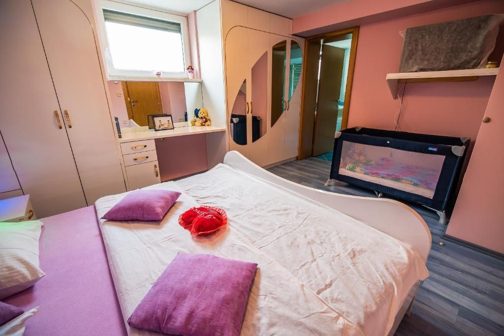 Habitació d'hotel amb llit, escriptori, armari i televisió.