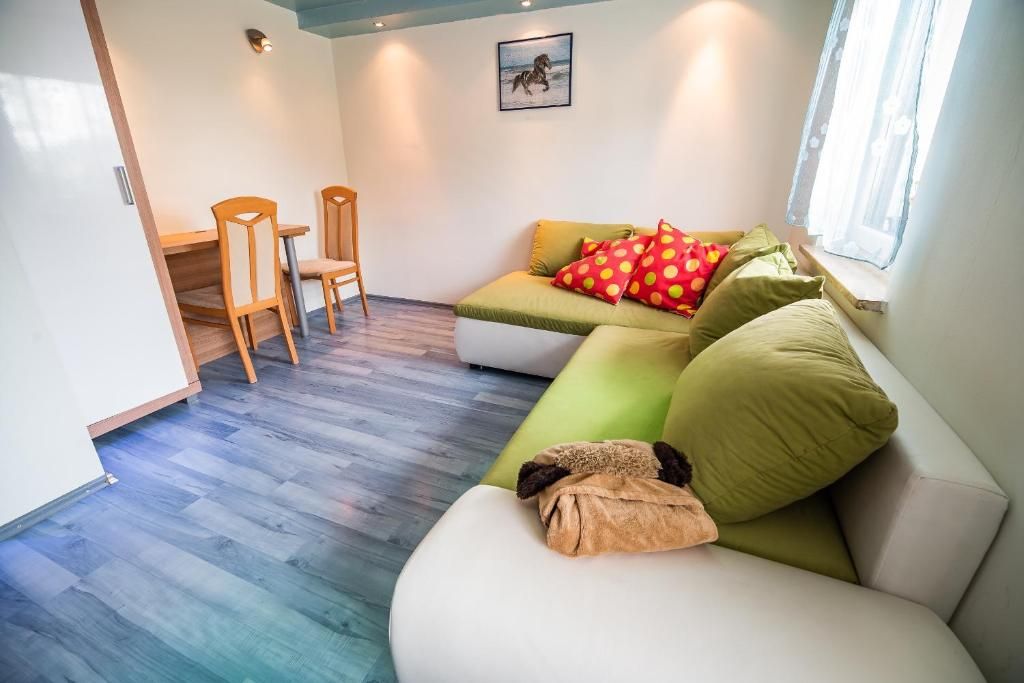 Una sala de estar con sofá, sillas y una mesa de comedor.