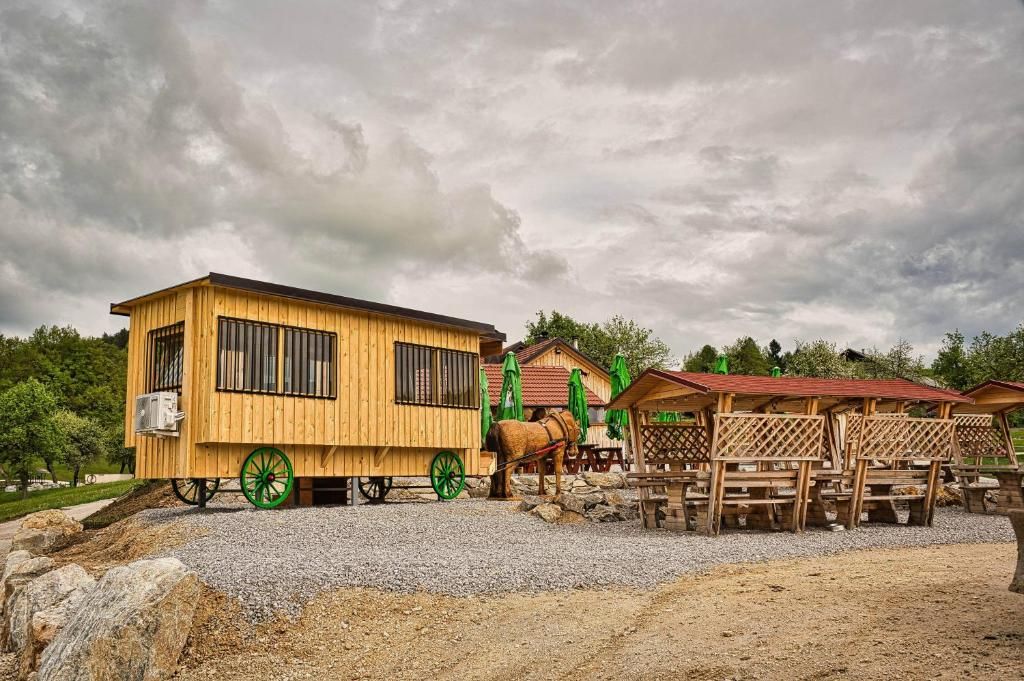 A wooden building with a cart and a horse, surrounded by outdoor seating areas.
