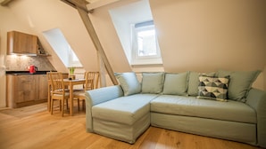 Un appartement-loft confortable comprenant un coin repas, un canapé et une cuisine.