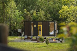 A small cabin with a yellow door, surrounded by trees. - The Wollombi Wanderer by Tiny Away (Wollombi)
