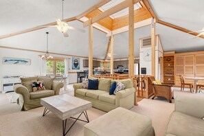Relax in a spacious living area with a comfortable seating arrangement, featuring a sofa set, coffee table, and wicker chair.
