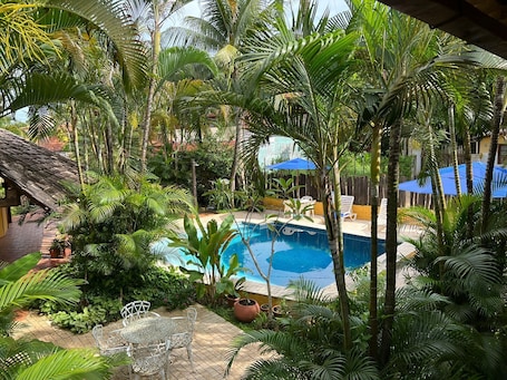 Una piscina al aire libre, sombrillas, sillones reclinables de piscina