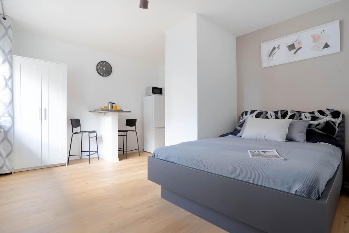 A modern bedroom with a bed, a desk, and a chair.