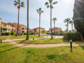 A resort with multiple buildings, palm trees, and well-maintained lawns.