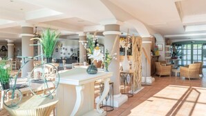 A spacious lobby with high ceilings, large windows, and a mix of seating areas including tables and chairs. - Les Calanques Spa Thalassothérapie by Interhome (Les Issambres)
