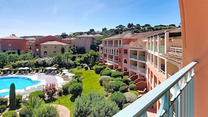 A resort with a swimming pool, lush greenery, and multi-story buildings with balconies. - Les Calanques Spa Thalassothérapie by Interhome (Les Issambres)