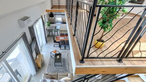Un interior moderno con una escalera, comedor y vistas al espacio de estar.