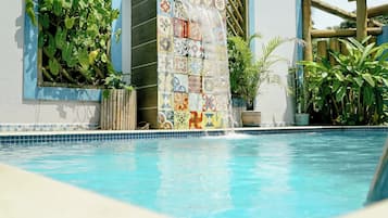 Una piscina al aire libre, sillones reclinables de piscina