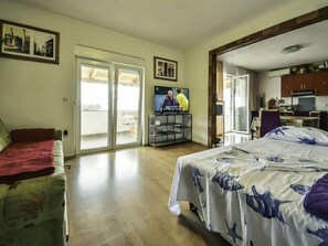 A hotel room with a bed, a sofa, a TV, and a kitchenette. - Apartment Zorić by Interhome (Privlaka)