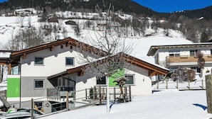 A modern two-story building with a sloped roof, a balcony, and a view of a snowy mountain. - Fankhauser by Interhome (Kaprun)