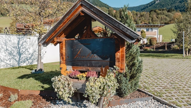 A wooden cabin with a sign that reads "Hotel Tankhäuser" surrounded by a gravel area and plants. - Fankhauser by Interhome (Kaprun)