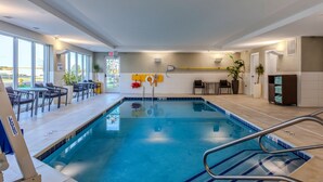 An indoor swimming pool with clear lane markings, a lifeguard chair, and a pool ladder. - TownePlace Suites by Marriott Chesterfield (New Baltimore)