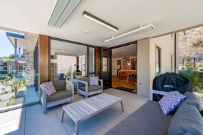 A modern outdoor living area with a sofa, chairs, and a table. - Lakeside Luxury 2 Bedroom (Wanaka)