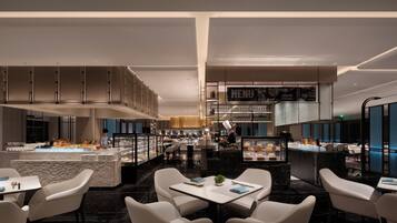 A modern restaurant with a central island, seating area, and a menu display.
