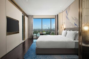 A hotel room with a large bed, a flat-screen TV, a dining table with chairs, and a view of a cityscape. - HUALUXE Shanghai Changfeng Park by IHG (Shanghai)