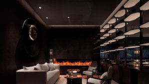 Un salón moderno con sofá, sillones, una mesa de centro y una chimenea.