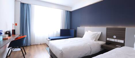 Habitación de hotel moderna con una cama grande, un escritorio con silla y vistas al exterior.