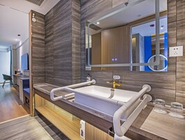 Un baño moderno con un espejo grande, un lavabo blanco y un mueble de tocador de madera.