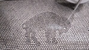 A bathroom floor with a mosaic pattern of circular tiles.