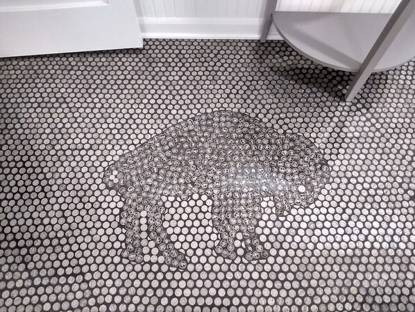 A bathroom floor with a mosaic pattern of circular tiles.