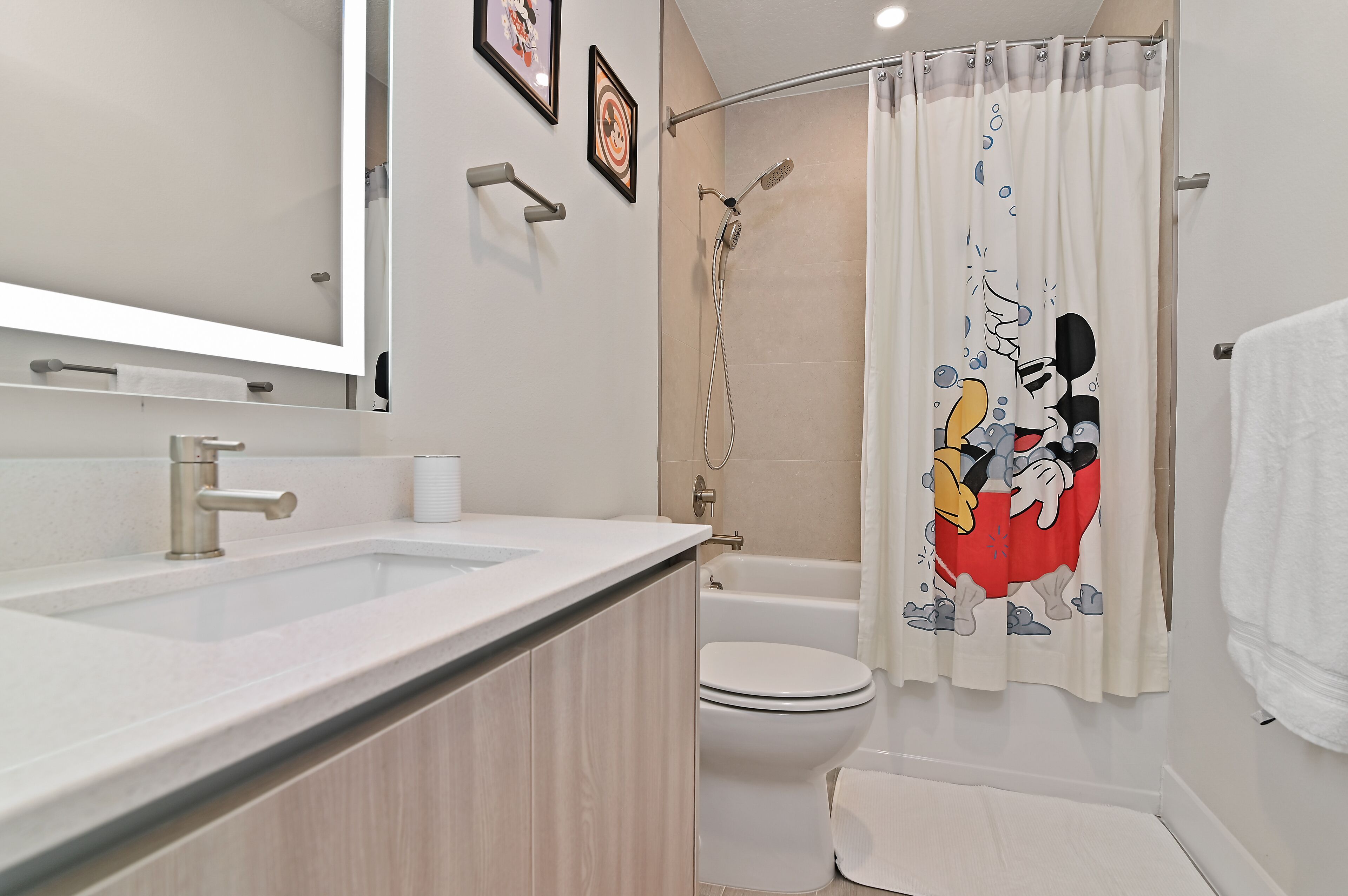 A modern bathroom with a sink, toilet, and shower.