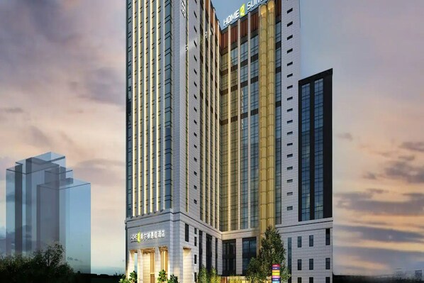 Un hôtel moderne, de grande hauteur, avec de nombreux étages, de grandes fenêtres et une enseigne bien visible indiquant qu’il fait partie de la chaîne Home2Suites.