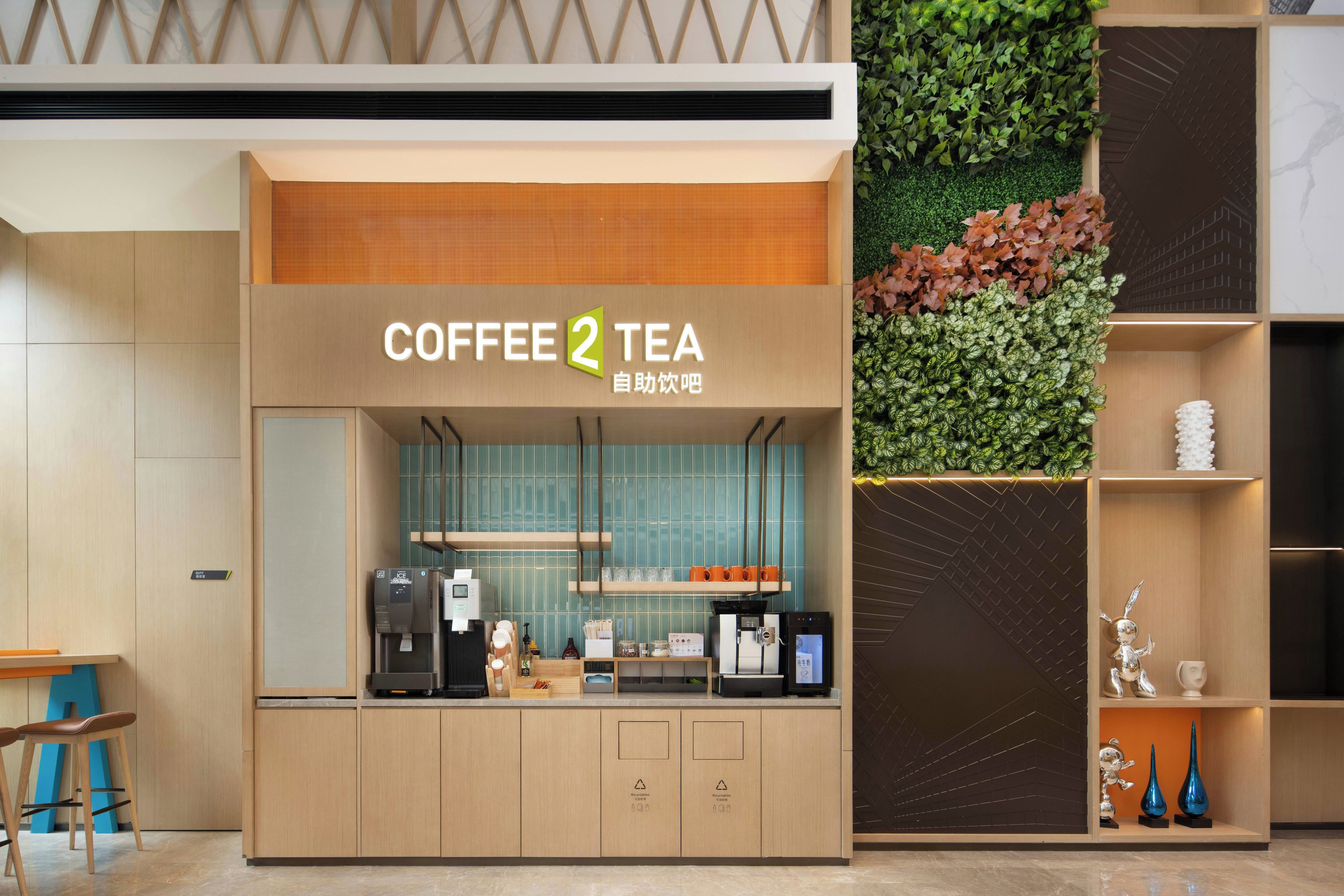 A coffee and tea kiosk with a modern design, featuring a signboard, a water dispenser, and a digital coffee machine.
