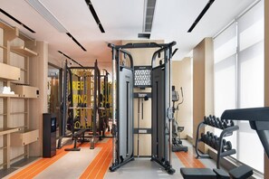Uma academia moderna com diversos equipamentos de exercício, incluindo um suporte para agachamento e halteres.