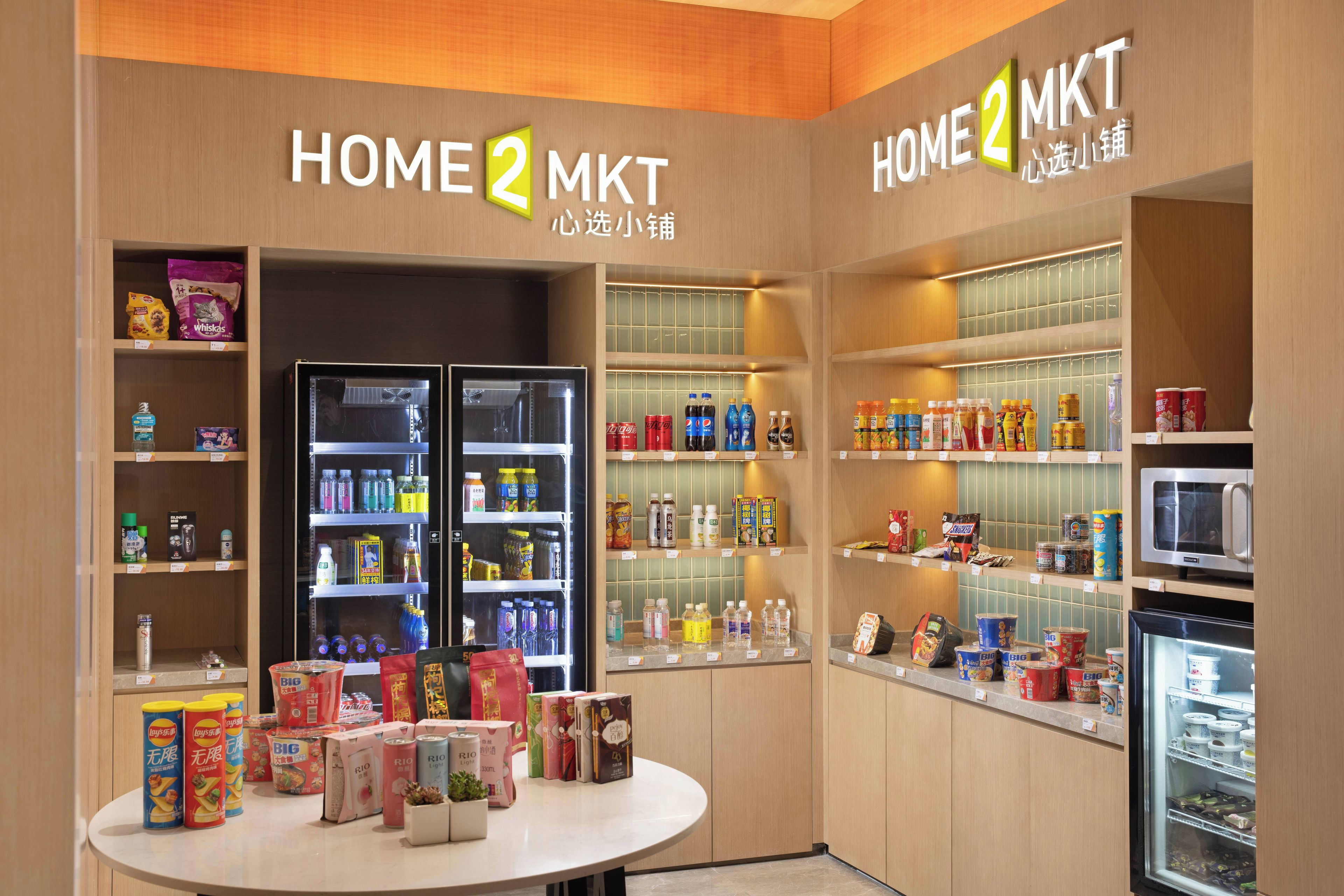 A store interior with shelves stocked with beverages, snacks, and household items.