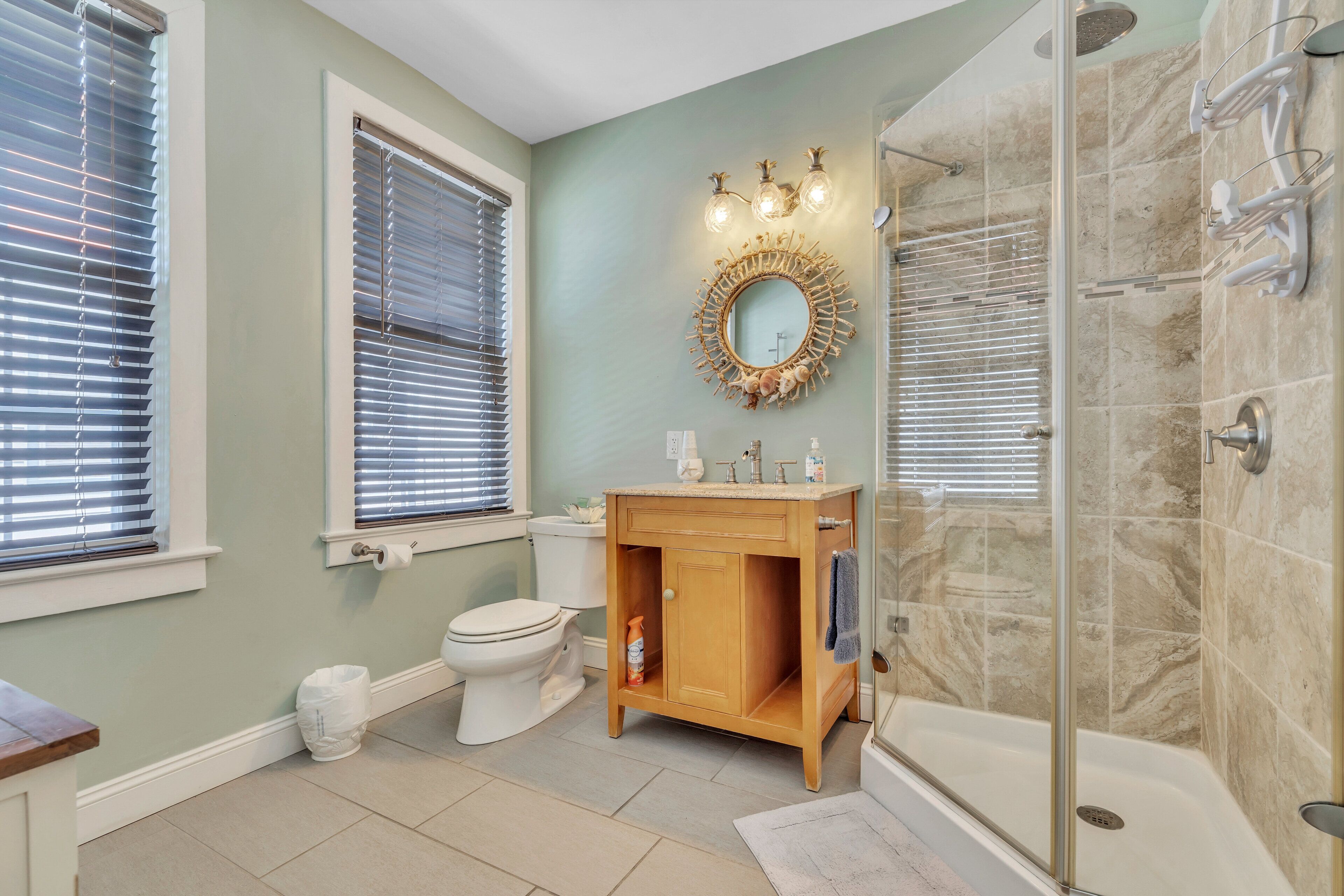 Une salle de bain comprenant des toilettes, un lavabo, un meuble-lavabo et un espace douche.