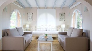 Ein Zimmer mit zwei Sofas, einem kleinen Tisch und einem Bett.