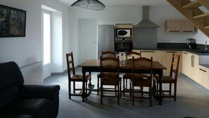 Een moderne keuken met houten kastjes, een inbouwoven en een hangende lamp.