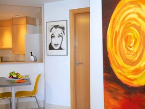 A modern kitchen with wooden cabinets, a dining table with chairs, and a framed artwork on the wall. - Horizonte by Interhome (Calpe/Calp)