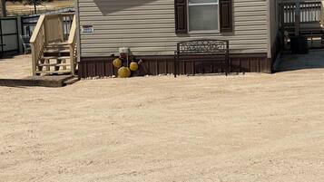 A single-story mobile home with a front porch and a 'Welcome' sign.