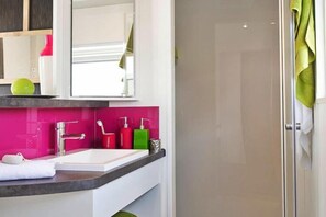 Bathroom features a sink, mirror, and glass shower enclosure.