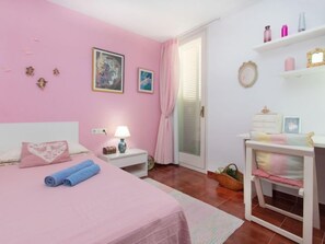 A pink-themed bedroom with a bed, bedside table, lamp, and a desk with a chair. - Cala Bona by Interhome (Blanes)